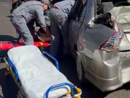Mulher fica presa às ferragens após ônibus atingir carro na Avenida Integração